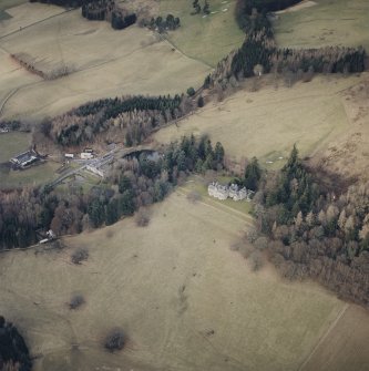 Oblique aerial view centred on the country house with farmsteading and cottage adjacent, taken from the S.