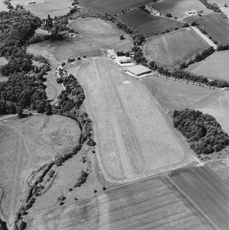 Oblique aerial view centred on the airfield and museum, taken from the ESE.
