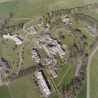Oblique aerial view centred on the hospital and chapel, taken from the W.