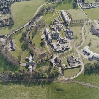 Oblique aerial view centred on the hospital and chapel with the remains of the rig adjacent, taken from the NE.