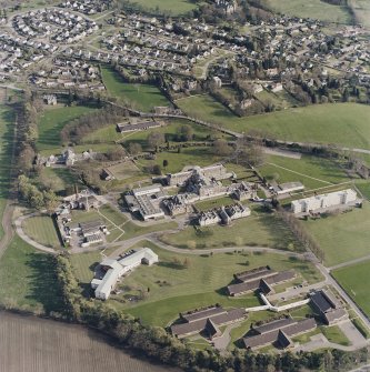 Oblique aerial view centred on the hospital and chapel with the remains of the rig adjacent, taken from the NNW.
