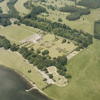 Oblique aerial view of Kinross House centred on the country house, garden, stables, and church and burial ground in the foreground, taken from the S.