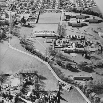 Oblique aerial view centred on the hospital and chapel with the remains of the rig adjacent, taken from the SE.