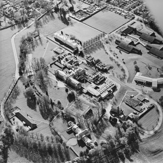 Oblique aerial view centred on the hospital and chapel, taken from the ESE.