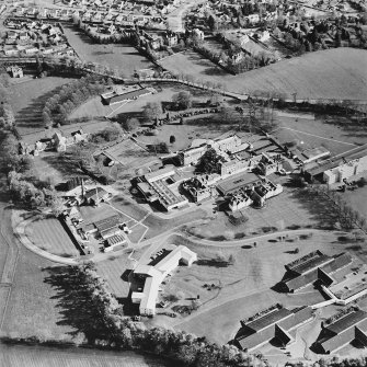 Oblique aerial view centred on the hospital and chapel with the remains of the rig adjacent, taken from the N.