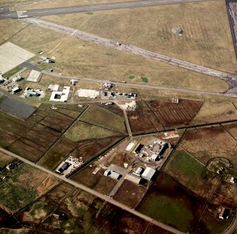 Oblique aerial view centred on the village with the airfield adjacent, taken from the SSE.