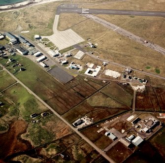 Oblique aerial view centred on the village with the airfield adjacent, taken from the SE.