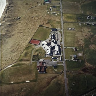 Oblique aerial view centred on the school, the museum and the hotel, with the site of the smithy adjacent, taken from the ESE.