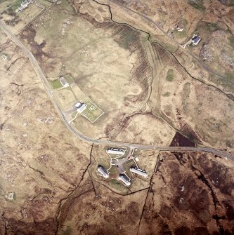 Oblique aerial view centred on the church, burial ground and manse with the houses adjacent, taken from the SE.