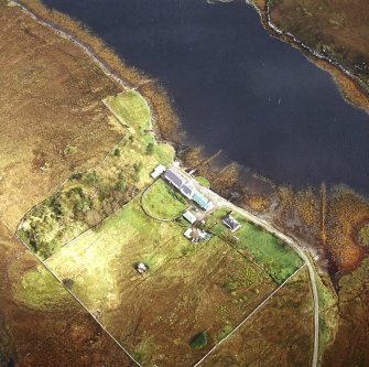 Oblique aerial view centred on the lodge and kennels with the remains of lazy beds adjacent, taken from the SW.