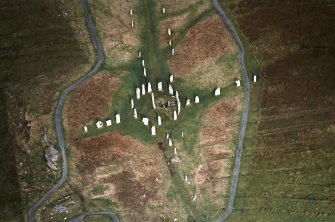 Oblique aerial view centred on the remains of the stone circle, stone alignments and chambered cairn, taken from the SSW.