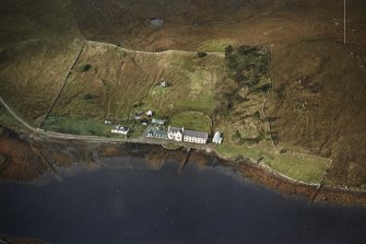 Oblique aerial view centred on the lodge and kennels with the remains of lazy beds adjacent, taken from the ENE.