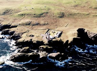 Oblique aerial view centred on the lighthouse with the enclosure and lazy beds adjacent, taken from the NNE.