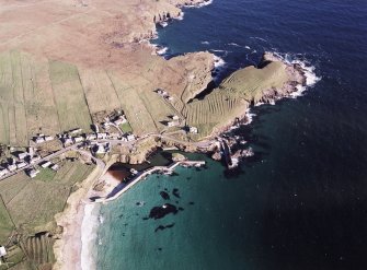 Oblique aerial view centred on the harbour and crofting township with the remains of the lazy beds adjacent, taken from the S.