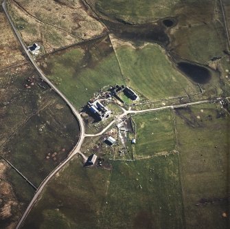 Oblique aerial view centred on the house, the farmsteading and the remains of the castle, taken from the NNE