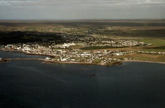 Oblique aerial view centred on the breakwater with the power station and town adjacent, taken from the SSE.