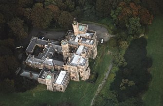 Oblique aerial view centred on the country house and college, taken from the SW.