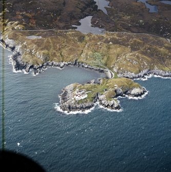 Oblique aerial view centred on the lighthouse with the head-dyke, field system and lazy beds adjacent, taken from the ESE.