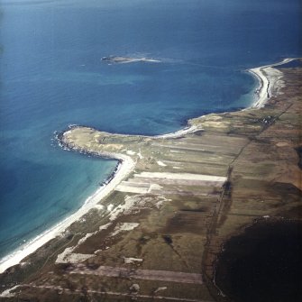 General oblique aerial view looking over the burial grounds towards Eilean Bheirean, taken from the S.
