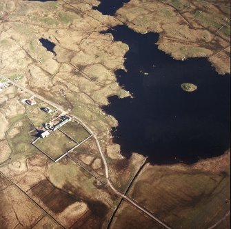 Oblique aerial view centred on the farmsteading and the farmhouse, with the remains of the dun adjacent, taken from the NW.