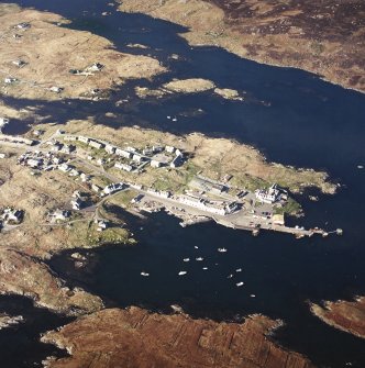 Oblique aerial view centred on the village, with the pier, the school and the hotel adjacent, taken from the SSW.