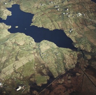 Oblique aerial view centred on the remains of the township, with the remains of the crannog and the township adjacent, taken from the WNW.