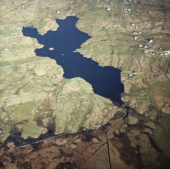Oblique aerial view centred on the remains of the township, with the remains of the crannog and the township adjacent, taken from the NW.