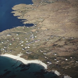 Oblique aerial view centred on the burial grounds with the harbour adjacent, taken from the WSW.