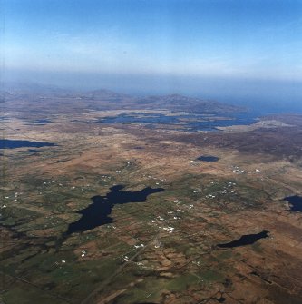 General oblique aerial view centred on crofting townships of  Garrynamonie and South Boisdale looking towards Lochboisdale in the distance, taken from the SW.