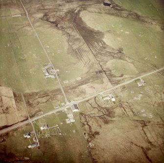 Oblique aerial view centred on part of the crofting township and the church with the remains of the crofting township adjacent, taken from the SSE.