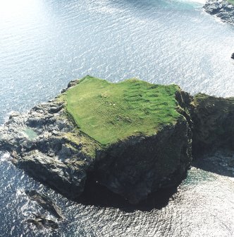 Oblique aerial view centred on the remains of the monastic settlement, taken from the NE.