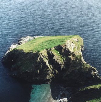 Oblique aerial view centred on the remains of the monastic settlement, taken from the NW.