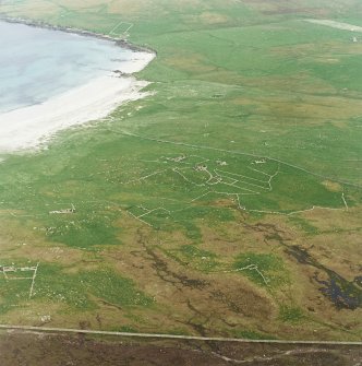 Oblique aerial view centred on the remains of the township and head-dyke, with the remains of the Viking settlement adjacent, taken from the NW.