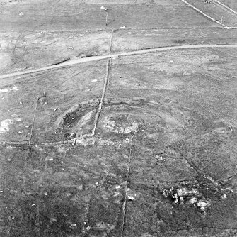 Oblique aerial view centred on the remains of the broch and field-system, taken from the SW.