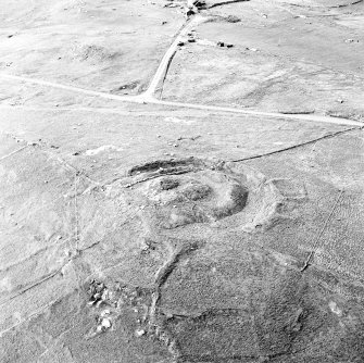 Oblique aerial view centred on the remains of the broch and field-system, taken from the SSE.