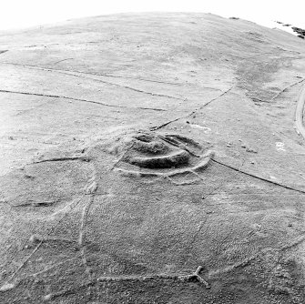 Oblique aerial view centred on the remains of the broch and field-system, taken from the SE.