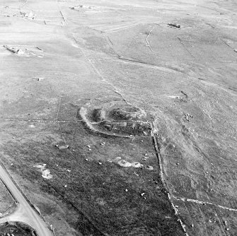 Oblique aerial view centred on the remains of the broch and field-system, taken from the NNW.