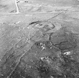 Oblique aerial view centred on the remains of the broch and field-system, taken from the SSW.
