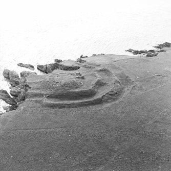 Oblique aerial view centred on the remains of the broch, taken from the ESE.