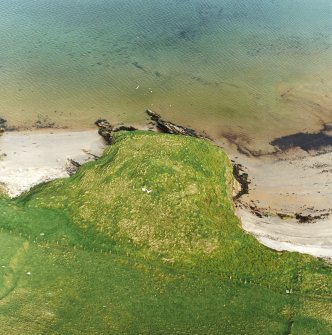 Oblique aerial view centred on the remains of the broch, taken from the WNW.