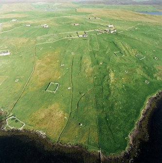 Oblique aerial view centred on the remains of the township, chapel,  burial ground and head-dyke with the remains of the burnt mound adjacent, taken from the NW.