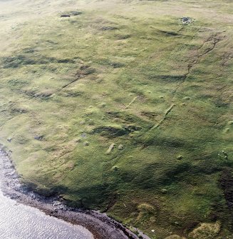 Oblique aerial view centred on the remains of the settlement and field-system, taken from the SE.