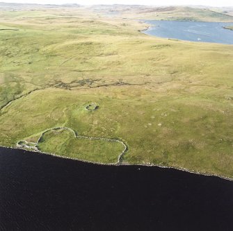 Oblique aerial view of the enclosure, stock enclosure, settlement, field-system and possible burnt mounds, taken from the S.