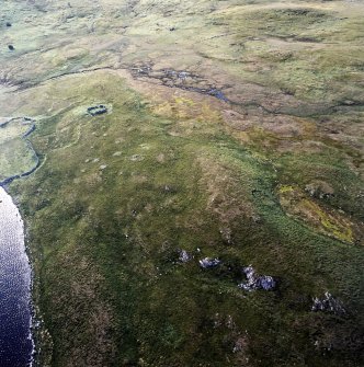 Oblique aerial view of the enclosure, stock enclosure, settlement, field-system and possible burnt mounds, taken from the ESE.