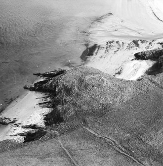 Oblique aerial view centred on the remains of the broch, taken from the NW.