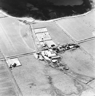 Oblique aerial view of Orphir, St Nicholas's Church, burial-ground and the Earl's Bu with mill, taken from the N. Also visible is the Bu of Orphir farmhouse and farmsteading.