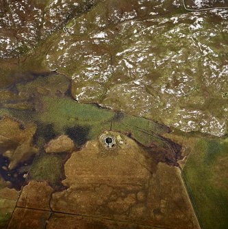 Oblique aerial view centred on the remains of the broch with the remains of the structure adjacent, taken from the E.