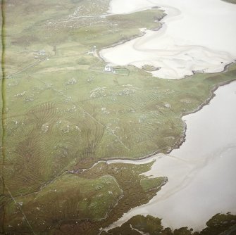 Oblique aerial view centred on the remains of the township and lazy beds with the old manse and burial ground adjacent, taken from the NW.