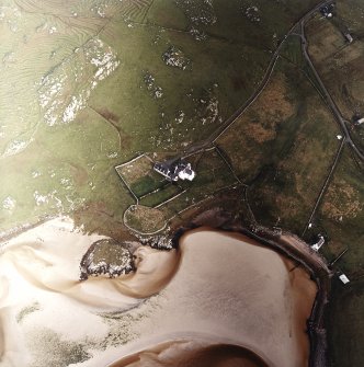 Oblique aerial view centred on the remains of the burial ground with the old manse, walled garden and lazy beds adjacent, taken from the SSW.