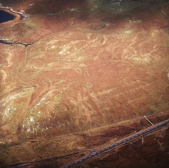 Oblique aerial view centred on the remains of the stone circle, taken from the SE.